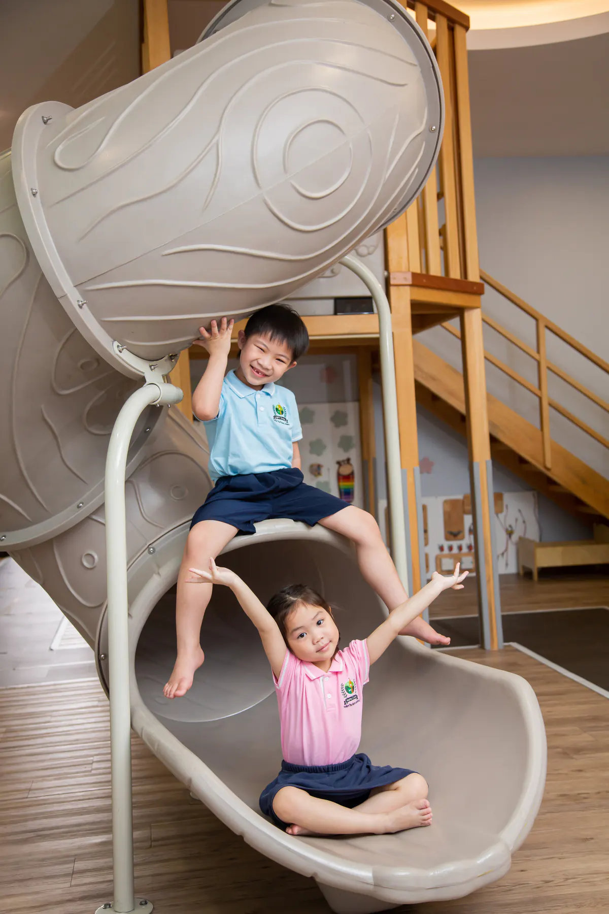 Two children building balance and coordination on an indoor slide